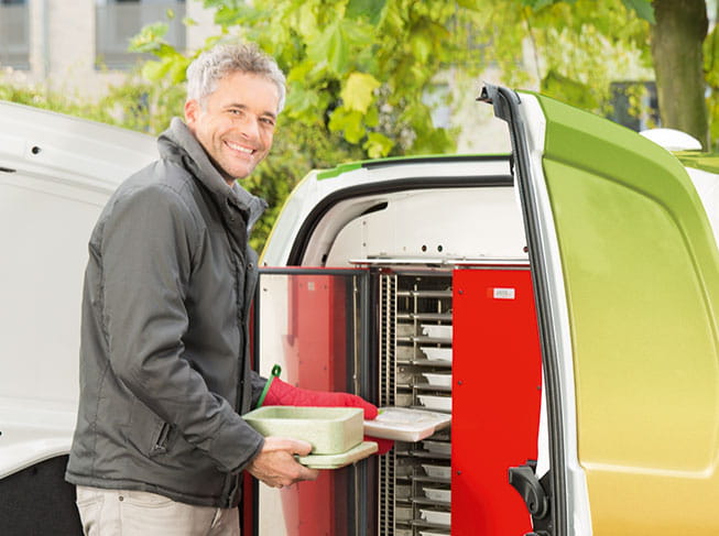 Kurier trägt Essen aus dem Ofen